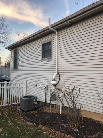 Low voltage fan on the side of the house and terminating above gutters because of the nearby window