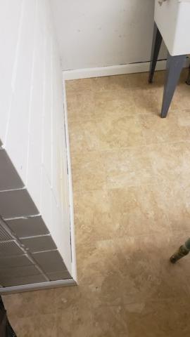 The floor in the laundry area has been finished, and the trim on the bottom of the wall that functions as a kick plate is being installed. This Thermal Dry Elite Tile has a marble look and is very comfortable underfoot.