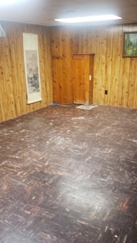 <p>Before photo of this basement, you can see how the wood paneling on the wall looks, and how dark the original flooring was.</p>