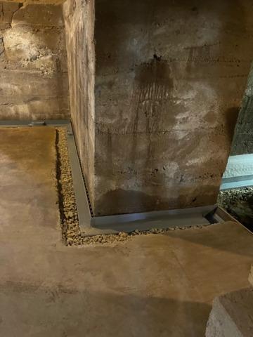 Our crew broke out the concrete floor perimeter, and installed our WaterGuard Below Floor Drain, followed by river rock.