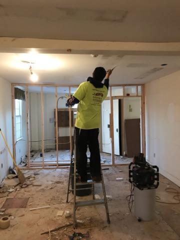 A crew member is spackling the ceiling.