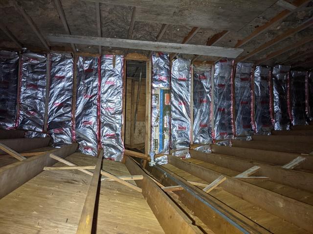 Fiberglass insulation with open space behind in the attic in TKE Fraternity House in Bloomington IL