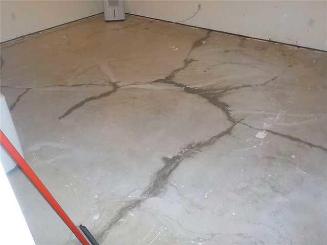 You can see in this picture all of the cracks that are in the floor of this basement room. Water was coming up through the cracks causing water to pool on the floor, hence the squeegee against the wall. The floor was removed due to the water intrusion and the homeowner wants to utilize the room again so they needed a solution.