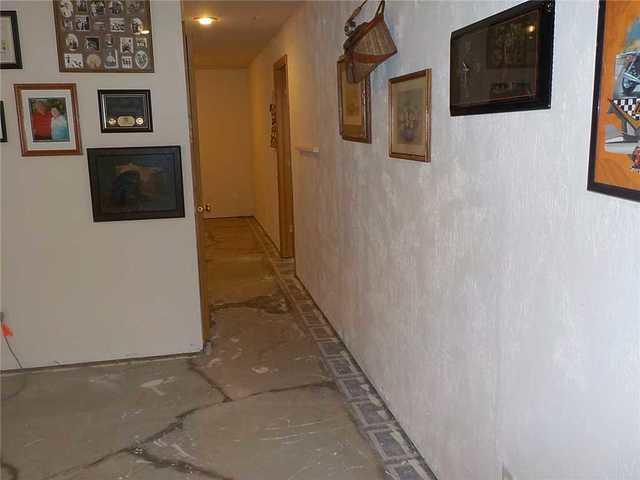 There were cracks all the way down the halls of the basement too. You can tell water was entering through them due to the dark color surrounding the cracks.