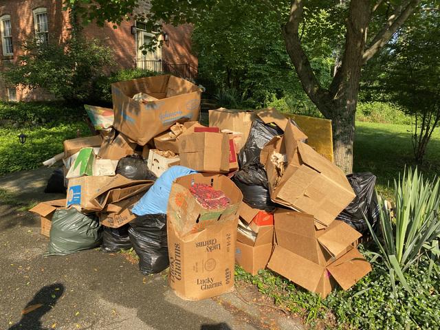 Miscellaneous books and items in pile in front of house