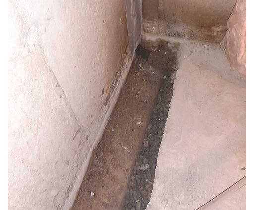 <p>Because the crack goes below the floor, a long trench is opened to expose the footing and gravel bed</p>