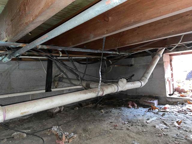 The walls of this crawl space are created with porous cinderblock walls, which means that air and moisture can pass through it and affect the crawl space. Efflorescence is visible in certain areas of the walls, which tells us that moisture has seeped through the walls, bringing along with it the salts and sediments of the cinderblocks to the surface, creating a powdery and chalky substance.