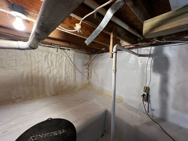 <p>The production crew spray foams the crawl space walls for insulation. The spray foam is installed over a layer of CleanSpace.</p>