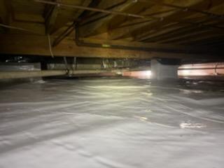 Once the crawl space is cleaned out and the mold is treated with an antimicrobial, a new vapor barrier is installed. This is the CleanSpace 10-mil Vapor Barrier. It is a heavy-duty liner designed to withstand service persons crawling on it and is overlapped and sealed at all seams, wrapped and sealed around all piers, and mechanically attached to the foundation walls about 6 inches above outside grade, Completely sealing the crawlspace from the earth's moisture.