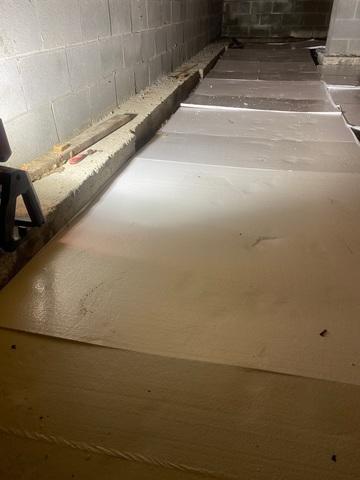 Insulation is installed on the floor of the crawlspace to help stop heat loss.