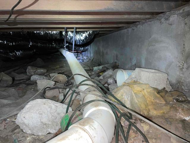 The walls of this crawl space were created using poured concrete. These walls are less porous than the typical cinderblock walls, but moisture can still seep through over time. When water forces its way through the walls, it brings along with it the inner salts and sediments to the surface. The discoloring and chalk-like substance on the walls is proof of this. It is also possible that the moisture has leaked in through the rim and band.