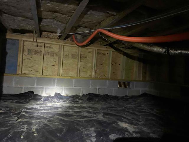 The 6-mill liner originally installed over the dirt flooring of this crawl space is unsealed and ripped in several places. This exposes the dirt floor, allowing the earth's moisture to rise into the crawl space, raising the relative humidity. Many areas of the crawl space floor were also covered with debris and materials, making it difficult for service persons to maneuver.