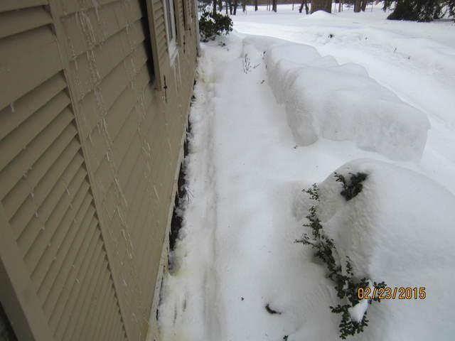 You can see the water that is running down behind the ice-clogged gutters is discharging right next to the foundation.  That water may find its way into the basement!