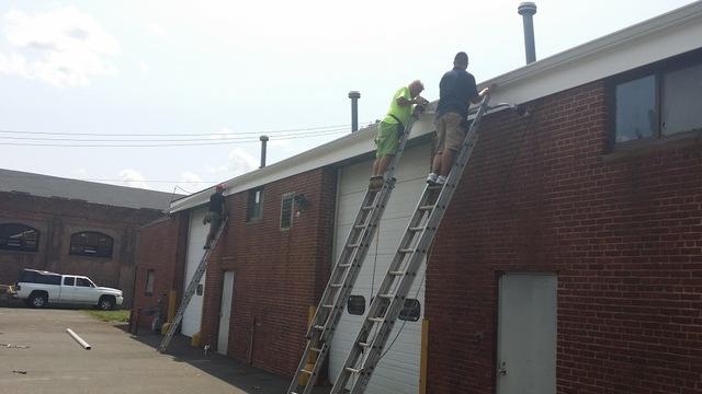 Hard working staff completing a gutter installation