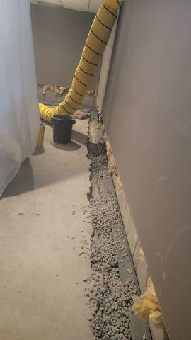 The concrete slab floor is removed so that the Waterguard system can be placed on top of the footer.