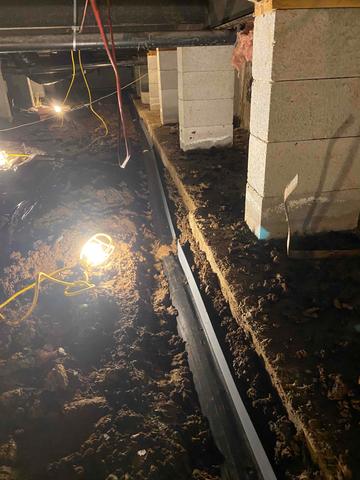 Our workers examine the current state of the crawl space, including the smart pipe, which appears to be detaching.