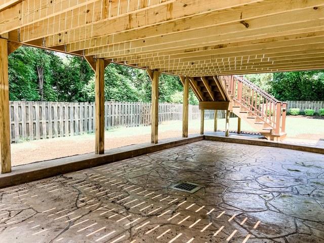 Underneath deck stamped concrete patio.