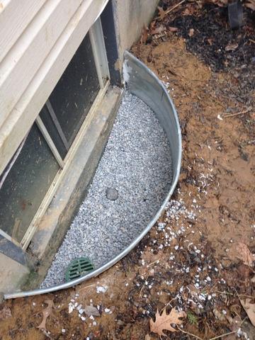 This is a photo of the outside window well. As you can see, there is no longer any standing water in the window well and we have filled it with more gravel to aid in the path of least resistance.