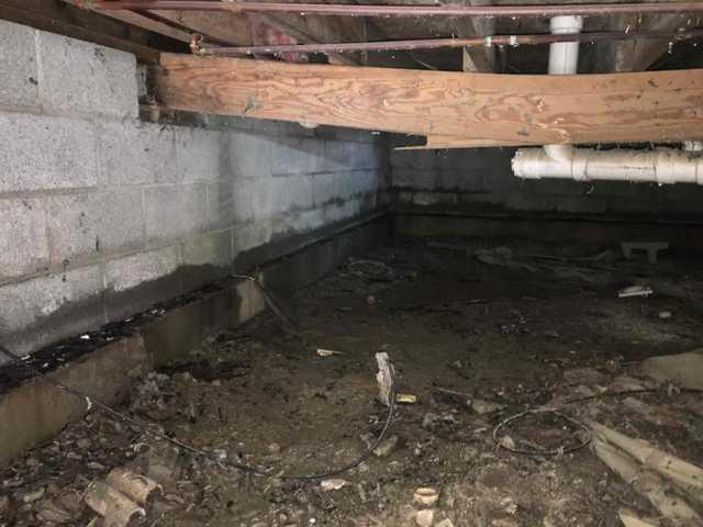 We began our project by installing 106 linear feet of drain tile around perimeter of crawlspace and tied into a SuperSump with a Zoeller M98 sump pump. We discharged that plumbing to the outside through an IceGuard that runs to a 15 foot underground downspout. To combat the heavy areas of mold, we sprayed Mold-X.

To help manage moisture and humidity, we installed a CleanSpace Encapsulation System over exterior walls, across the floor, and around existing pilasters. The encapsulation system was buttoned along the walls, with all seams on the walls and floor overlapped, then sealed with urethane, and secured with industrial tape. 

To help support the structure, we installed a new beam on existing support columns and pocket. We also sistered floor joists with new lumber. 

Finally, we installed an AprilAire E100 and drained that into the SuperSump.