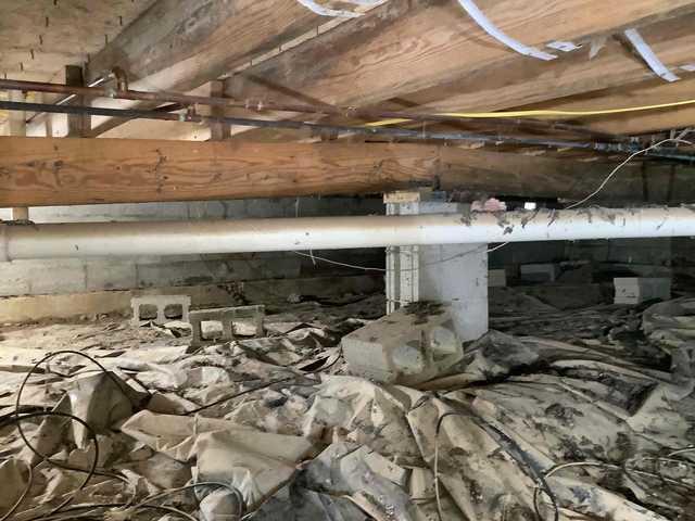 We began our project by installing 106 linear feet of drain tile around perimeter of crawlspace and tied into a SuperSump with a Zoeller M98 sump pump. We discharged that plumbing to the outside through an IceGuard that runs to a 15 foot underground downspout. To combat the heavy areas of mold, we sprayed Mold-X.

To help manage moisture and humidity, we installed a CleanSpace Encapsulation System over exterior walls, across the floor, and around existing pilasters. The encapsulation system was buttoned along the walls, with all seams on the walls and floor overlapped, then sealed with urethane, and secured with industrial tape. 

To help support the structure, we installed a new beam on existing support columns and pocket. We also sistered floor joists with new lumber. 

Finally, we installed an AprilAire E100 and drained that into the SuperSump.