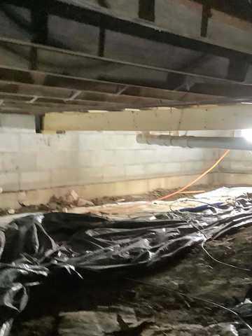 We began our project by installing 106 linear feet of drain tile around perimeter of crawlspace and tied into a SuperSump with a Zoeller M98 sump pump. We discharged that plumbing to the outside through an IceGuard that runs to a 15 foot underground downspout. To combat the heavy areas of mold, we sprayed Mold-X.

To help manage moisture and humidity, we installed a CleanSpace Encapsulation System over exterior walls, across the floor, and around existing pilasters. The encapsulation system was buttoned along the walls, with all seams on the walls and floor overlapped, then sealed with urethane, and secured with industrial tape. 

To help support the structure, we installed a new beam on existing support columns and pocket. We also sistered floor joists with new lumber. 

Finally, we installed an AprilAire E100 and drained that into the SuperSump.