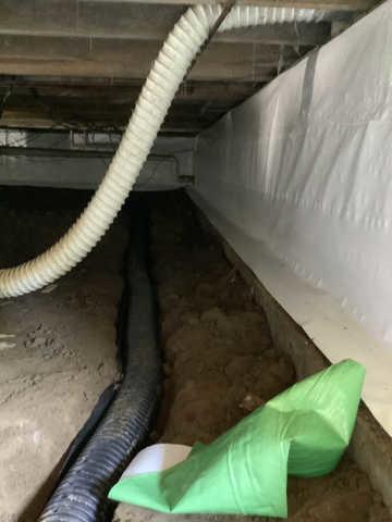 We began our project by installing 106 linear feet of drain tile around perimeter of crawlspace and tied into a SuperSump with a Zoeller M98 sump pump. We discharged that plumbing to the outside through an IceGuard that runs to a 15 foot underground downspout. To combat the heavy areas of mold, we sprayed Mold-X.

To help manage moisture and humidity, we installed a CleanSpace Encapsulation System over exterior walls, across the floor, and around existing pilasters. The encapsulation system was buttoned along the walls, with all seams on the walls and floor overlapped, then sealed with urethane, and secured with industrial tape. 

To help support the structure, we installed a new beam on existing support columns and pocket. We also sistered floor joists with new lumber. 

Finally, we installed an AprilAire E100 and drained that into the SuperSump.