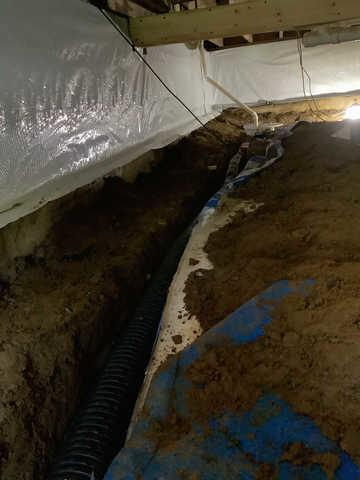 We began our project by installing 106 linear feet of drain tile around perimeter of crawlspace and tied into a SuperSump with a Zoeller M98 sump pump. We discharged that plumbing to the outside through an IceGuard that runs to a 15 foot underground downspout. To combat the heavy areas of mold, we sprayed Mold-X.

To help manage moisture and humidity, we installed a CleanSpace Encapsulation System over exterior walls, across the floor, and around existing pilasters. The encapsulation system was buttoned along the walls, with all seams on the walls and floor overlapped, then sealed with urethane, and secured with industrial tape. 

To help support the structure, we installed a new beam on existing support columns and pocket. We also sistered floor joists with new lumber. 

Finally, we installed an AprilAire E100 and drained that into the SuperSump.