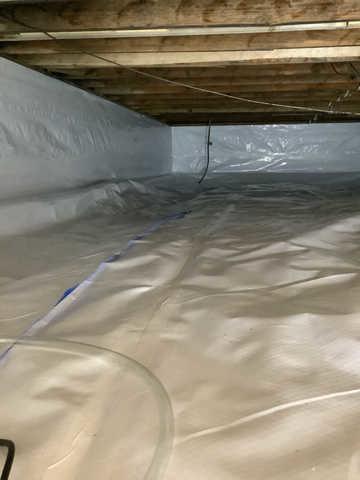 We began our project by installing 106 linear feet of drain tile around perimeter of crawlspace and tied into a SuperSump with a Zoeller M98 sump pump. We discharged that plumbing to the outside through an IceGuard that runs to a 15 foot underground downspout. To combat the heavy areas of mold, we sprayed Mold-X.

To help manage moisture and humidity, we installed a CleanSpace Encapsulation System over exterior walls, across the floor, and around existing pilasters. The encapsulation system was buttoned along the walls, with all seams on the walls and floor overlapped, then sealed with urethane, and secured with industrial tape. 

To help support the structure, we installed a new beam on existing support columns and pocket. We also sistered floor joists with new lumber. 

Finally, we installed an AprilAire E100 and drained that into the SuperSump.