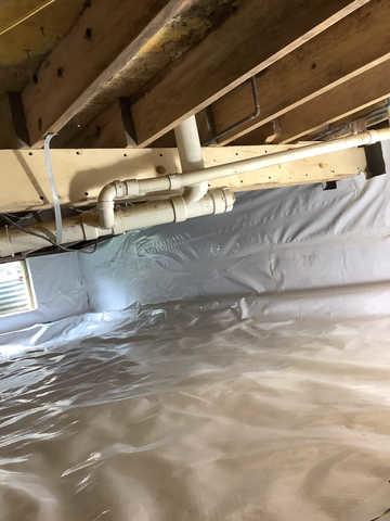 We began our project by installing 106 linear feet of drain tile around perimeter of crawlspace and tied into a SuperSump with a Zoeller M98 sump pump. We discharged that plumbing to the outside through an IceGuard that runs to a 15 foot underground downspout. To combat the heavy areas of mold, we sprayed Mold-X.

To help manage moisture and humidity, we installed a CleanSpace Encapsulation System over exterior walls, across the floor, and around existing pilasters. The encapsulation system was buttoned along the walls, with all seams on the walls and floor overlapped, then sealed with urethane, and secured with industrial tape. 

To help support the structure, we installed a new beam on existing support columns and pocket. We also sistered floor joists with new lumber. 

Finally, we installed an AprilAire E100 and drained that into the SuperSump.