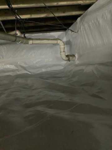 We began our project by installing 106 linear feet of drain tile around perimeter of crawlspace and tied into a SuperSump with a Zoeller M98 sump pump. We discharged that plumbing to the outside through an IceGuard that runs to a 15 foot underground downspout. To combat the heavy areas of mold, we sprayed Mold-X.

To help manage moisture and humidity, we installed a CleanSpace Encapsulation System over exterior walls, across the floor, and around existing pilasters. The encapsulation system was buttoned along the walls, with all seams on the walls and floor overlapped, then sealed with urethane, and secured with industrial tape. 

To help support the structure, we installed a new beam on existing support columns and pocket. We also sistered floor joists with new lumber. 

Finally, we installed an AprilAire E100 and drained that into the SuperSump.