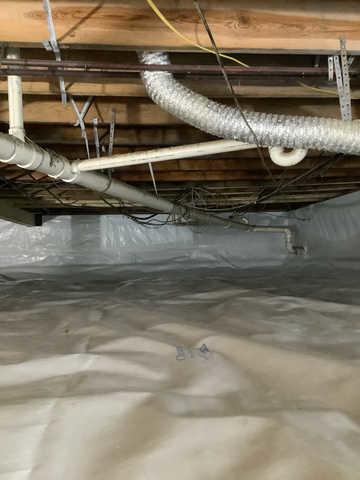 We began our project by installing 106 linear feet of drain tile around perimeter of crawlspace and tied into a SuperSump with a Zoeller M98 sump pump. We discharged that plumbing to the outside through an IceGuard that runs to a 15 foot underground downspout. To combat the heavy areas of mold, we sprayed Mold-X.

To help manage moisture and humidity, we installed a CleanSpace Encapsulation System over exterior walls, across the floor, and around existing pilasters. The encapsulation system was buttoned along the walls, with all seams on the walls and floor overlapped, then sealed with urethane, and secured with industrial tape. 

To help support the structure, we installed a new beam on existing support columns and pocket. We also sistered floor joists with new lumber. 

Finally, we installed an AprilAire E100 and drained that into the SuperSump.