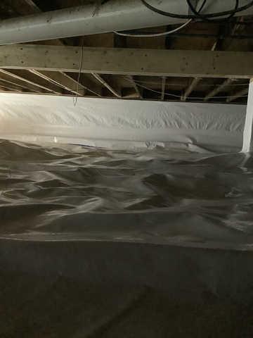 We began our project by installing 106 linear feet of drain tile around perimeter of crawlspace and tied into a SuperSump with a Zoeller M98 sump pump. We discharged that plumbing to the outside through an IceGuard that runs to a 15 foot underground downspout. To combat the heavy areas of mold, we sprayed Mold-X.

To help manage moisture and humidity, we installed a CleanSpace Encapsulation System over exterior walls, across the floor, and around existing pilasters. The encapsulation system was buttoned along the walls, with all seams on the walls and floor overlapped, then sealed with urethane, and secured with industrial tape. 

To help support the structure, we installed a new beam on existing support columns and pocket. We also sistered floor joists with new lumber. 

Finally, we installed an AprilAire E100 and drained that into the SuperSump.