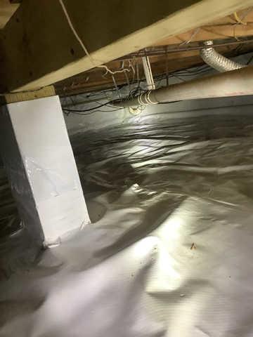 We began our project by installing 106 linear feet of drain tile around perimeter of crawlspace and tied into a SuperSump with a Zoeller M98 sump pump. We discharged that plumbing to the outside through an IceGuard that runs to a 15 foot underground downspout. To combat the heavy areas of mold, we sprayed Mold-X.

To help manage moisture and humidity, we installed a CleanSpace Encapsulation System over exterior walls, across the floor, and around existing pilasters. The encapsulation system was buttoned along the walls, with all seams on the walls and floor overlapped, then sealed with urethane, and secured with industrial tape. 

To help support the structure, we installed a new beam on existing support columns and pocket. We also sistered floor joists with new lumber. 

Finally, we installed an AprilAire E100 and drained that into the SuperSump.