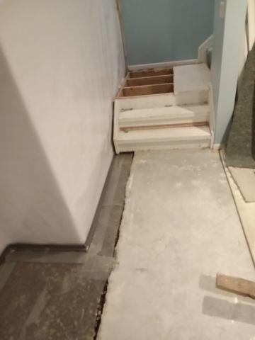 To ensure that the moisture was collected from all the walls along the perimeter in the basement, our crew discussed the option of temporarily removing and reinstalling a small section of the stairs to effectively run the drainage system.