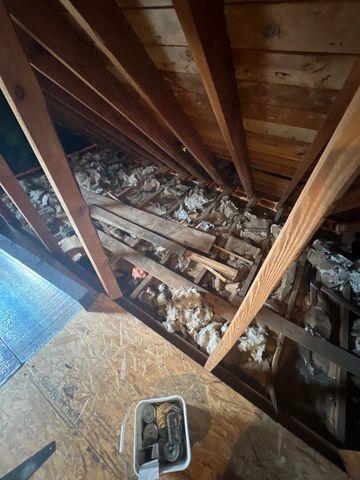 Old crumpled pieces of paper and newspapers were used as a wasted attempt to insulate this attic.  The start of the Super Deck is seen here with Silver Glo insulation panels lining the floor of the attic.