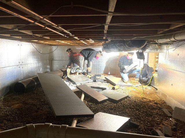 Our production team carefully measures and installs materials to insulate the walls and cover the dirt and rock floors.