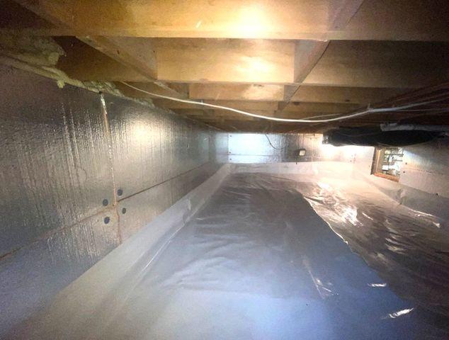 Silver Glo insulation panels cover the walls of this crawl space and spray foam seals up the rim joists to keep out any unconditioned, external air.  Clean Space covers the floor to keep moisture from the wet dirt floors contained below.