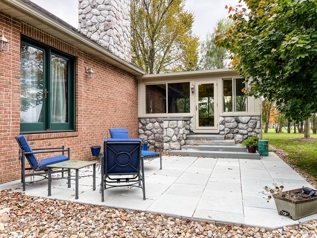 This side Entrance to the sunroom is complete with a paver patio and concrete steps inviting the entrance to the sunroom.