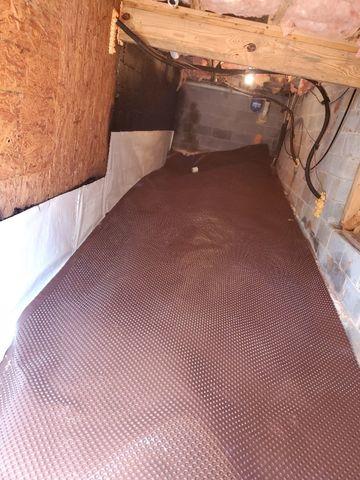 A layer of drainage matting under the vapor barrier helps water to drain to the waterproofing system and acts as a cushion to prevent punctures in the vapor barrier.