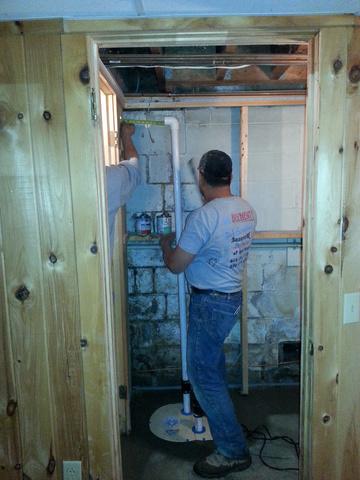 This image shows one of our technicians plumbing the discharge line for the TripleSafe sump to take the water from the system out of the home.