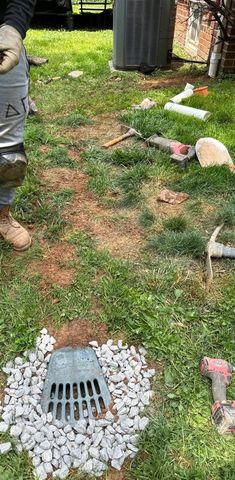 At the end of the pipe delivering rain away from the home is a cap that can be stepped on or mowed over.  This will allow water to drain into the yard when full.