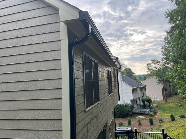 New Black Gutter Shutter seamless Gutter and downspout installed.