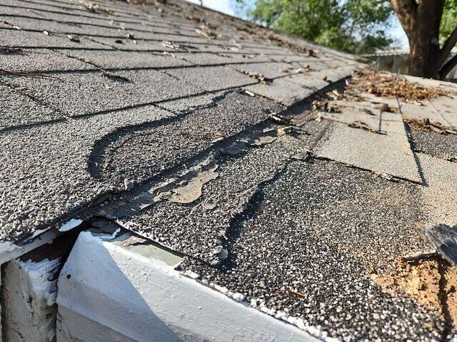 Torn and wide-damaged ashpalt shingles