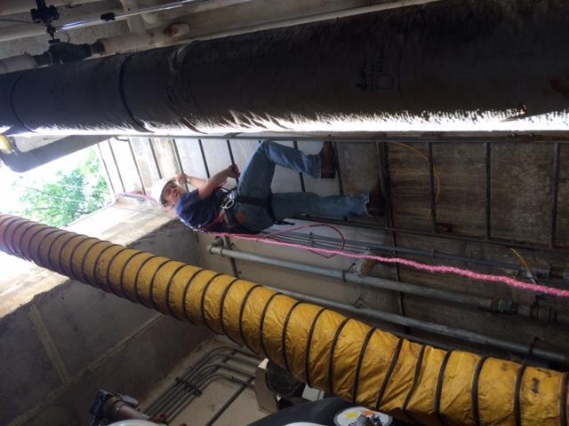 Matt climbing out from an inspection of the water pump system at a School in Wolcott, CT.