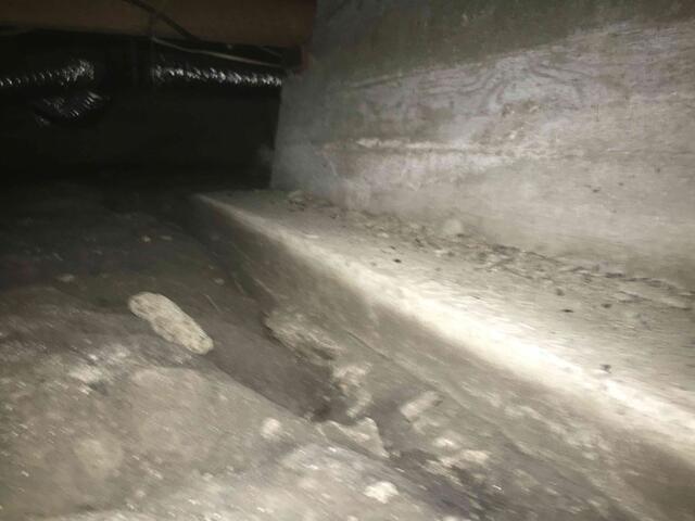 Water trails from flowing streams of water in crawl space