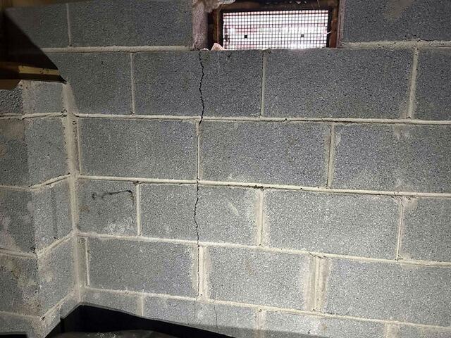 A vertical line shows a crack starting from the opening of the window to the foundation footing.