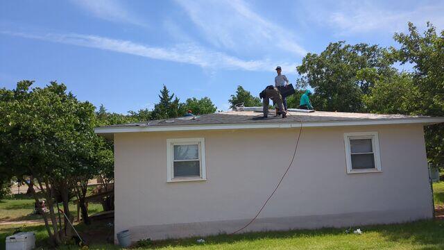 Placing the shingles down on the roof.