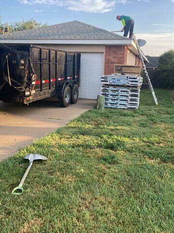 Crew members starting the process of removing the shingles.