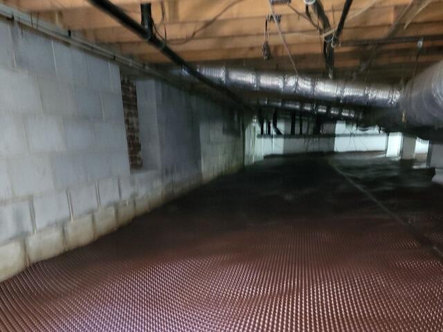 After clearing the crawlspace of debris, our crew installed the Drainage Matting.