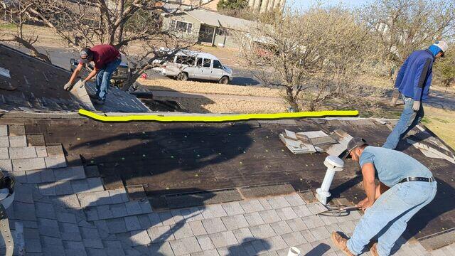 Crew members removing the old shingles.